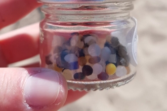 Nurdles in a jar on the beach