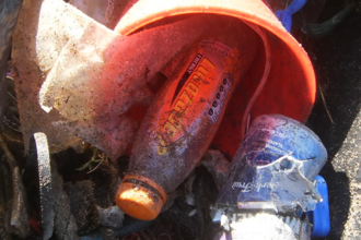 A bag of beach litter including plastic bottles, bits of plastic and rope